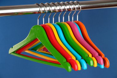 mavi arka plan üzerinde renkli elbise askıları