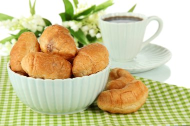 Tasty croissants and cup of coffee on table on white background
