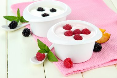 Delicious yogurt with fruit and berries on table close-up clipart