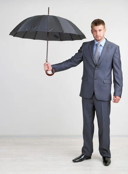 Businessman with umbrella. on gray background — Stock Photo, Image