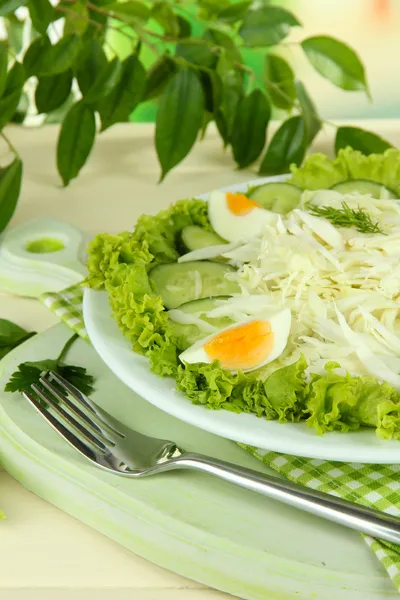 Delicious salad with eggs, cabbage and cucumbers on wooden table — Stock Photo, Image