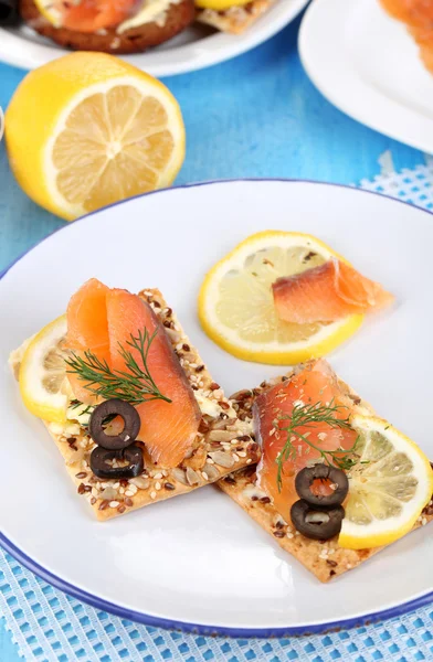 Salmon sandwiches on plate on wooden table close-up — Stock Photo, Image