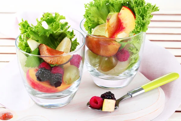 Salada de frutas em copos, no fundo de madeira — Fotografia de Stock