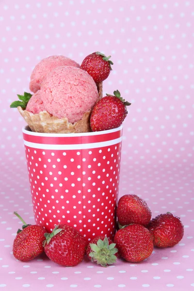 Apetitivo helado rosa con cono de waffle en taza sobre fondo de lunares — Foto de Stock