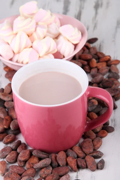 Cocoa drink with spices, zephyr and cocoa beans on wooden background — Stock Photo, Image