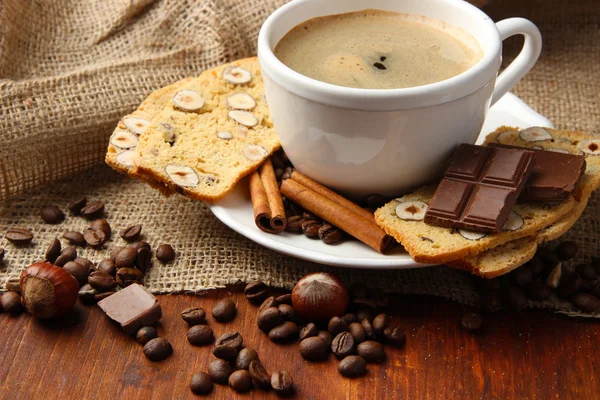 Taza de sabroso café con sabrosas galletas italianas, sobre fondo de madera —  Fotos de Stock