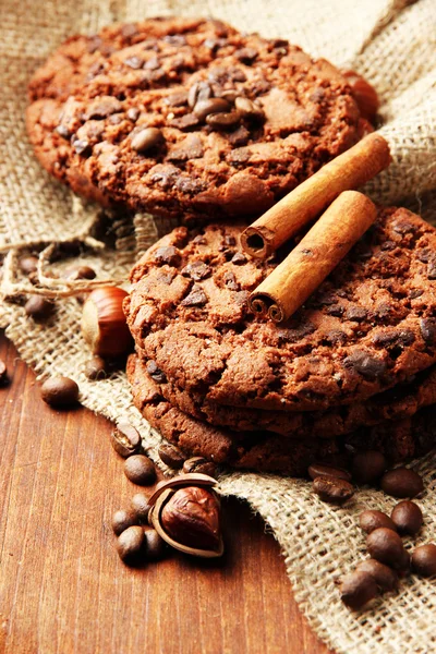 Homemade cookies with sesame seeds, chocolate, on wooden table, on sackcloth background — Stock Photo, Image