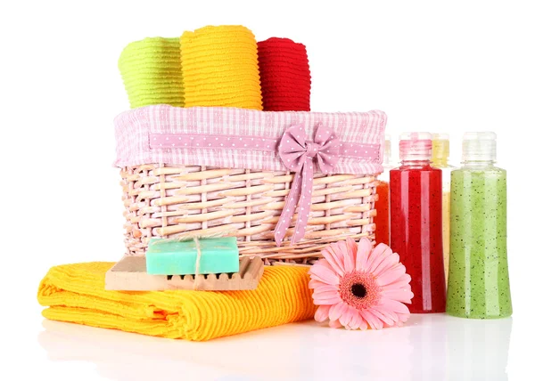 Toallas coloridas en cesta, botellas de cosméticos y jabón, aisladas en blanco —  Fotos de Stock