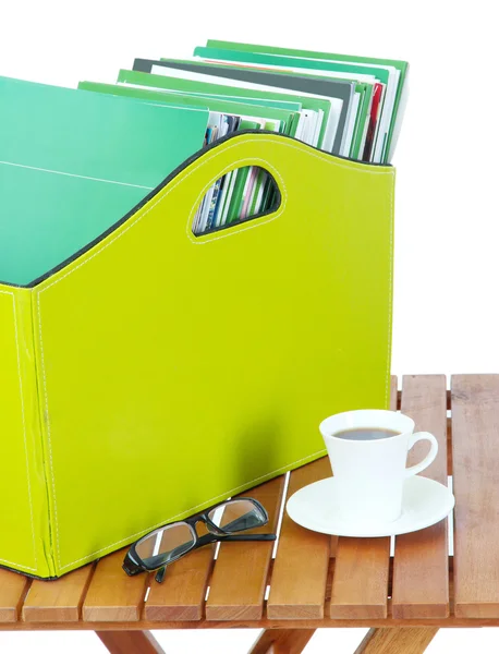 Magazines and folders in green box on bedside table in room — Stock Photo, Image