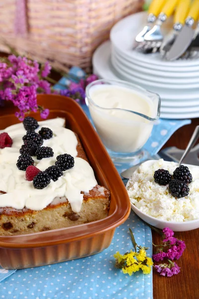 Käseauflauf mit Rosinen in Pfanne auf Serviette auf Holztisch Großaufnahme — Stockfoto