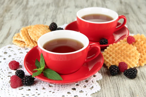 クッキーとテーブルのクローズ アップの漿果を持つ茶のカップ — ストック写真