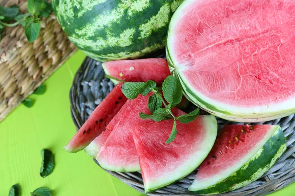 Reife Wassermelonen auf Korbblech auf Holztisch — Stockfoto