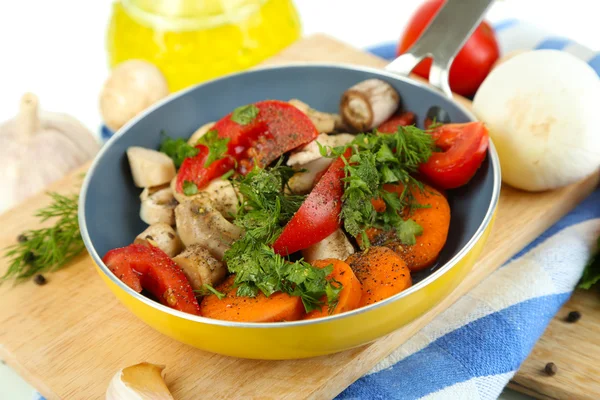 Légumes frais tranchés dans une casserole sur du bois isolé sur du blanc — Photo