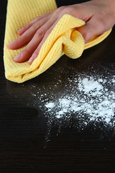 Hand wiping wooden surface with yellow rag — Stock Photo, Image