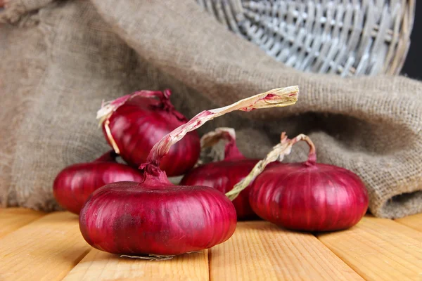 Cebollas rojas frescas sobre mesa de madera — Foto de Stock