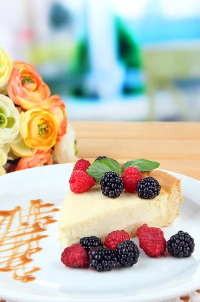 Slice of cheesecake with raspberry and blackberry on plate, on bright background — Stock Photo, Image