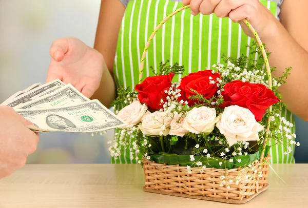 Florist makes flowers bouquet in wicker basket — Stock Photo, Image