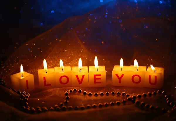 Candles with printed sign I LOVE YOU,on blur lights background — Stock Photo, Image