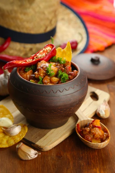 Chili Corn Carne - традиционная мексиканская кухня, в горшочке, на салфетке, на деревянном фоне — стоковое фото