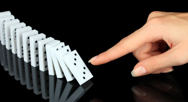 Mano spingendo domino isolato su nero — Foto Stock