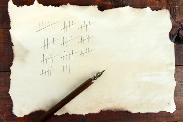 Contando días dibujando palos sobre papel sobre fondo de madera — Foto de Stock