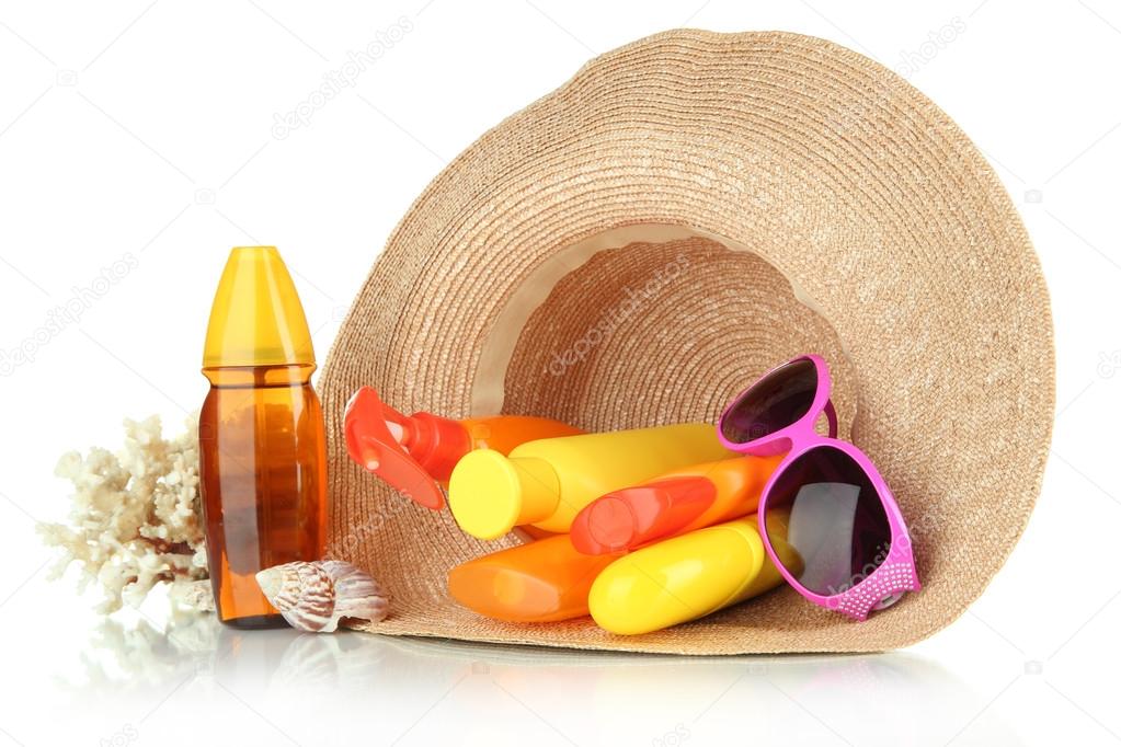 Bottles with suntan cream and sunglasses in hat isolated on white