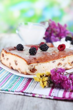 doğal zemin üzerine ahşap masa peçeteye tabakta üzerine üzümlü peynirli güveç