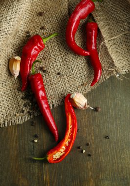 Red hot chili biber ve sarımsak, çul, ahşap zemin üzerinde