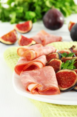 Beyaz ahşap masa üzerinde jambon ile lezzetli incir