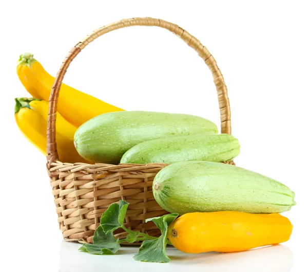 Ruwe gele en groene courgette in rieten mand, geïsoleerd op wit — Stockfoto