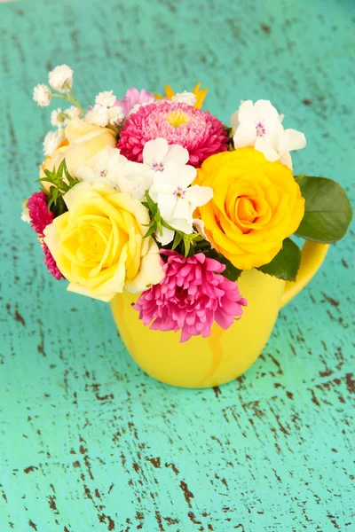 Beautiful bouquet of bright flowers in color vase, on bright background — Stock Photo, Image