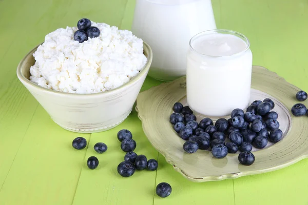 Färska mjölkprodukter med blåbär på träbord närbild — Stockfoto