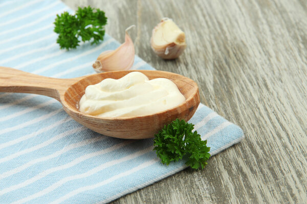 Сливки в ложке на столе крупным планом
