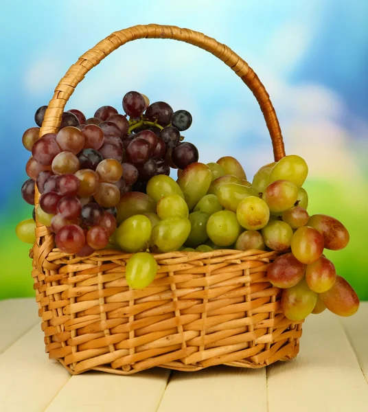 Свежий виноград на плетеном коврике на ярком фоне — стоковое фото