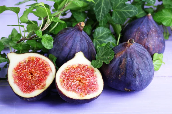 Ripe figs in leaves on wooden table close-up — Stock Photo, Image