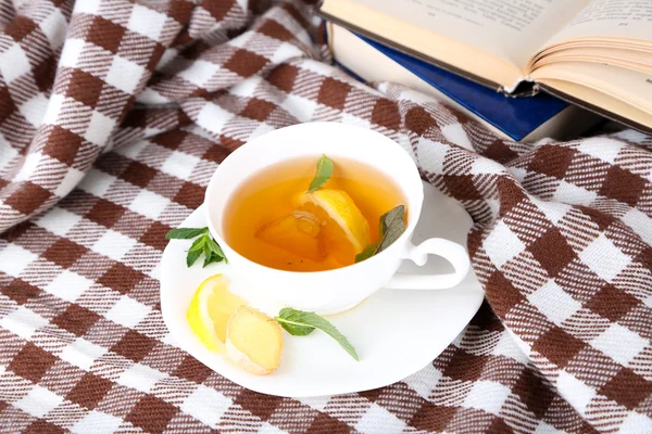Kopje thee met gember op plaid met een boek — Stockfoto