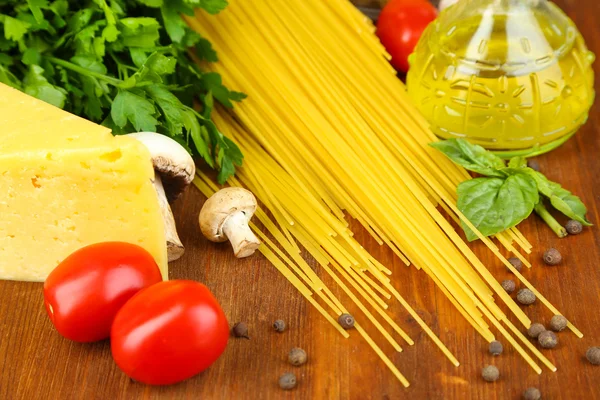 Pasta con aceite, queso y verduras en la mesa de madera de cerca —  Fotos de Stock