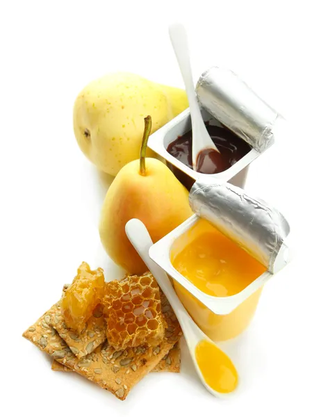 Dolci saporiti in bicchieri di plastica aperti e favi di miele, isolati su bianco — Foto Stock