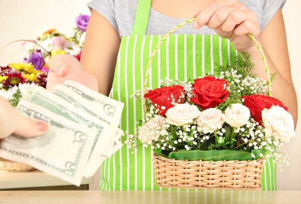 Florist makes flowers bouquet in wicker basket