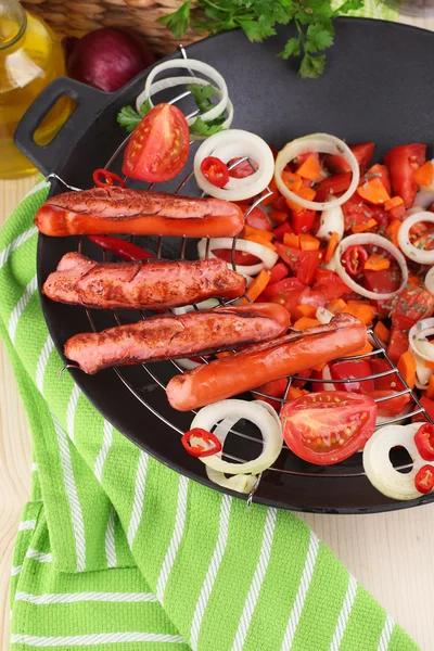 Deliciosas salchichas con verduras en wok sobre mesa de madera de cerca — Foto de Stock