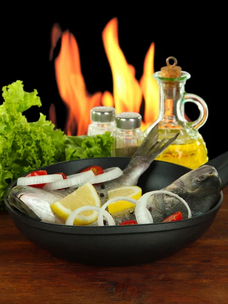 Dorado fish on table on fire background — Stock Photo, Image