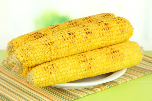 Zachwycający złoty kukurydza z grilla na stole na jasnym tle — Zdjęcie stockowe