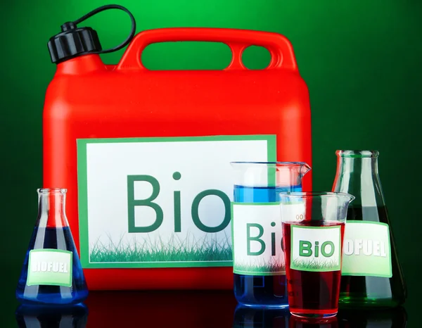 Bio fuels in canister and vials on green background — Stock Photo, Image