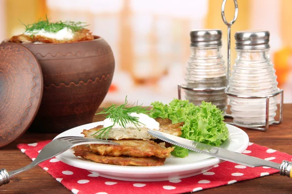 Potatis pannkakor i kruka, på träbord, på ljus bakgrund — Stockfoto