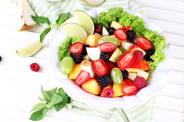 Fruktsallad i plattan på träbord — Stockfoto