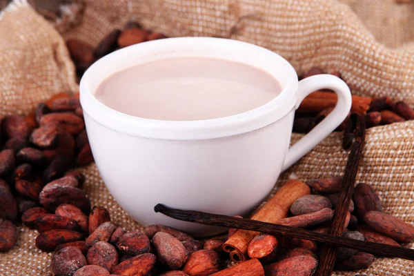 Cocoa drink and cocoa beans on sackcloth background — Stock Photo, Image