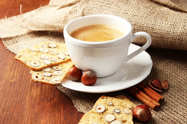 Tazza di caffè gustoso con biscotto italiano, su sfondo di legno — Foto Stock
