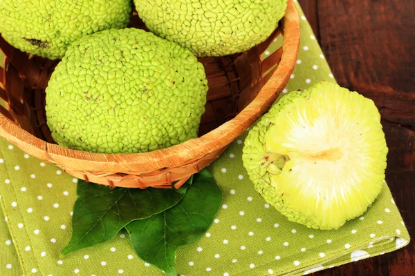 Osage Laranja frutas (Maclura pomifera) em cesta, sobre fundo de madeira — Fotografia de Stock