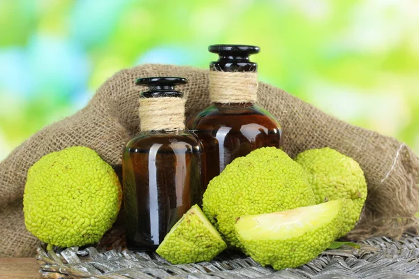 Sauge Fruits à l'orange (Maclura pomifera) et bouteilles de médicaments, sur table en bois, sur fond nature — Photo