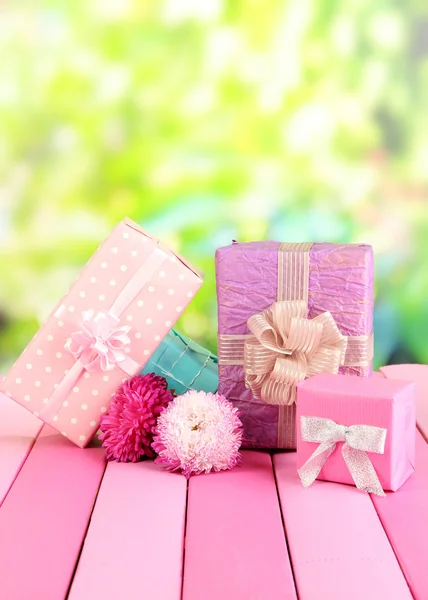 Gifts and flowers, on nature background — Stock Photo, Image